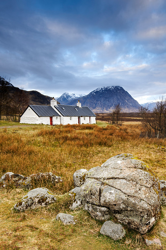 Glenncoe, Scotland, UK - Wide angle view of the iconic Black Rock Cottage in Glencoe. This area is known for having waterfalls and trails that climb peaks such as Buachaille Etive Mor that can be seen in the background.