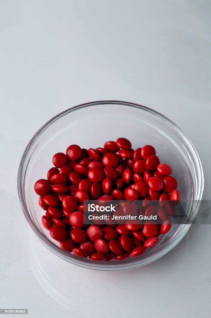 Small Red Candy Red Candy Coated Chocolate Button Sprinkles In A Bowl On Bright Marble ...