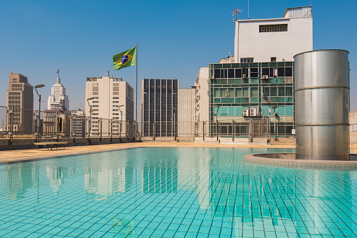 Sao Paulo, Brazil - July 26, 2022: Swimming pool on the terrace of Sesc May 24 building with city skyline view.