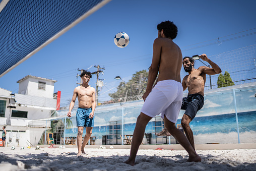 Male friends playing footvolley