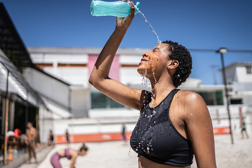 istock Woman pouring water over her face 1430437473