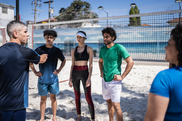 istock Coach talking to athletes during beach volleyball class 1430437592