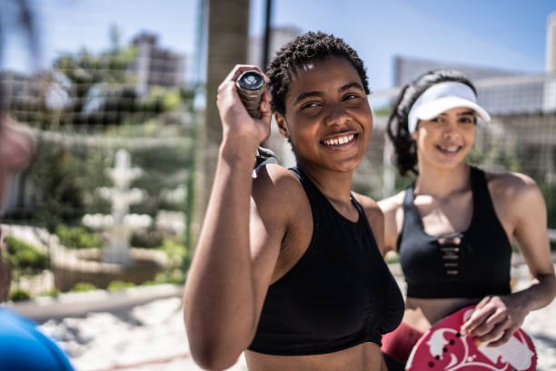 retrato de una mujer joven en una cancha de tenis de playa - common women teenage girls exercising fotografías e imágenes de stock