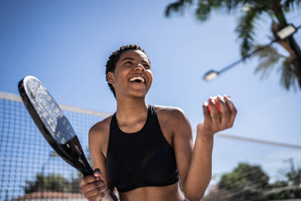femme heureuse célébrant pendant un match de tennis de plage - tennis women one person vitality photos et images de collection