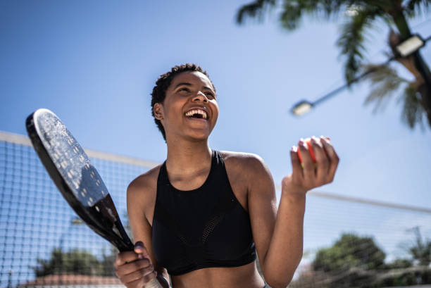 happy woman celebrating during beach tennis match - tennis women one person vitality imagens e fotografias de stock