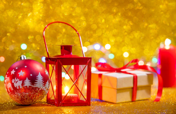 istock Red candle lantern and gift box, golden glitter Christmas background, red bauble with lights 1430438320