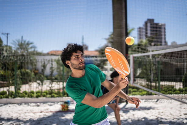 Young man playing beach tennis Young man playing beach tennis racketball stock pictures, royalty-free photos & images