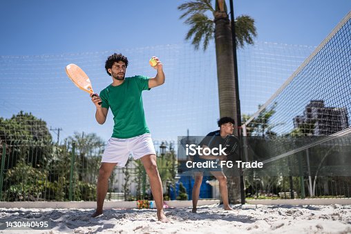 istock Young man playing beach tennis 1430440495