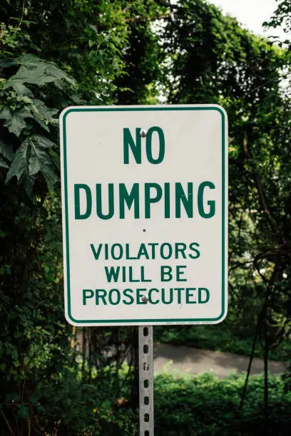 dating profile concept. white metal sign with green lettering warning "no dumping"