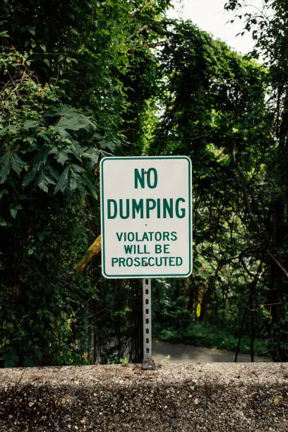 dating profile concept. white metal sign with green lettering warning "no dumping"