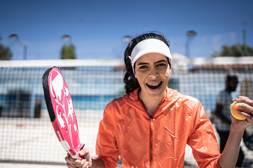 Portrait of a young woman playing beach tennis