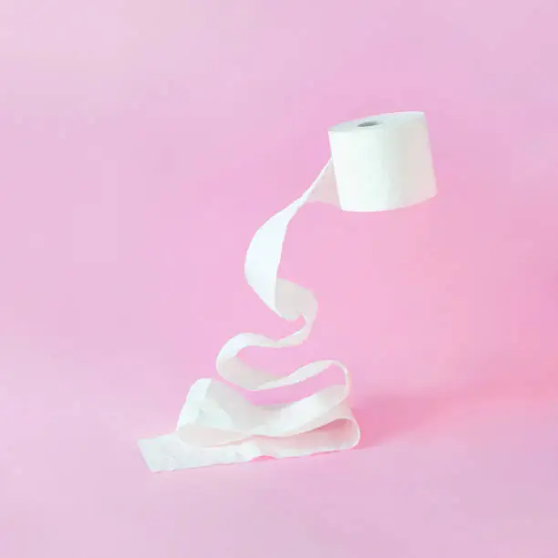 Christmas tree shape made of white toilet paper roll layers against bright pink background. Minimal concept art. Creative holiday surreal composition.