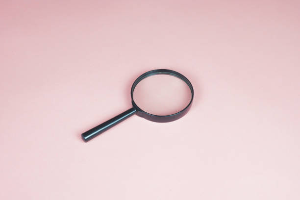 istock Magnifier on the pink background with copy space. Finding concept. 1430458571
