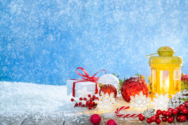 Christmas card background of Snowflakes snowing with candle lantern, gift box, baubles, candy cane, holly on snow snowing