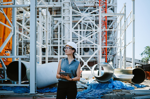 Female engineer at work, at the electricity power plant construction site.
