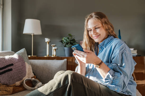 istock Young woman using a smart phone at home and smiling 1430474825