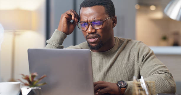 istock Stress black man, confused and laptop error glitch in work from home office. Frustrated, angry and headache freelance worker with internet scam mistake, connection crisis and online 404 virus problem 1430486613