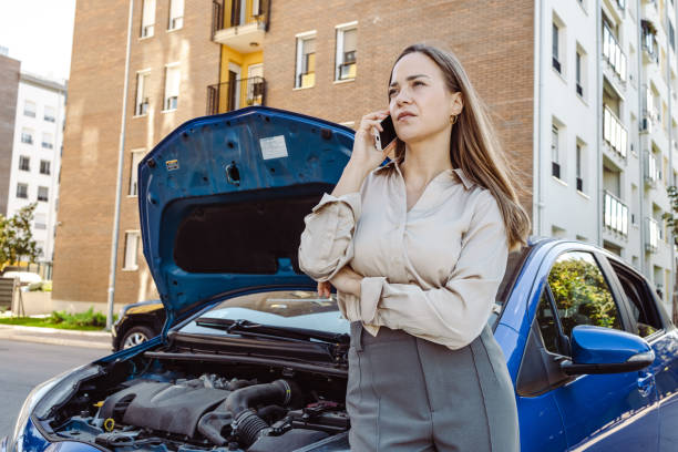 Young woman calls the roadside assistance service stock photo