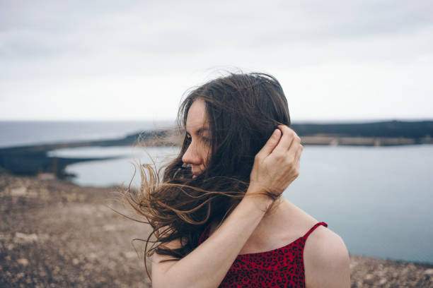 istock Woman at the seaside on a windy cloudy day 1430489444