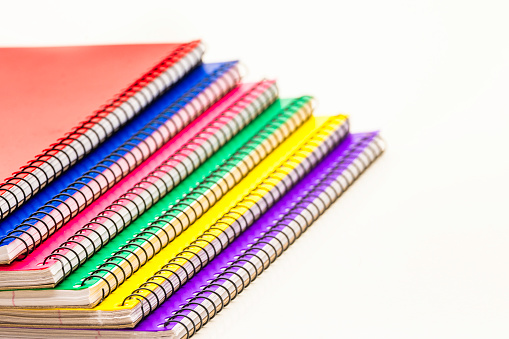 Stacked spiral binder notebooks. Blank colourful notebooks. Top view. 3D rendering illustration.