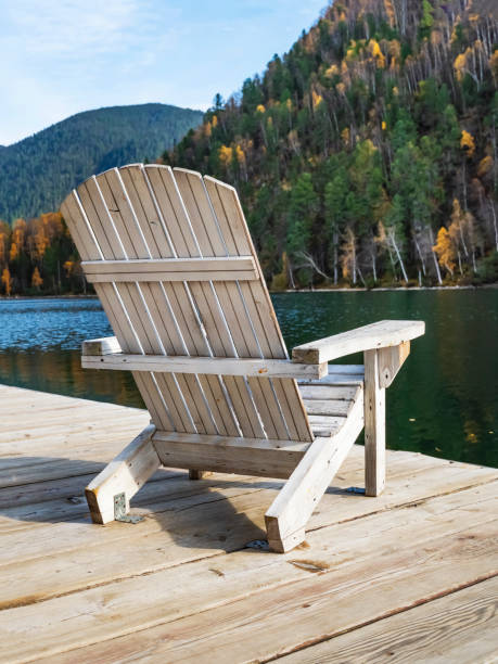 cadeira adirondack branca em uma doca de madeira com vista para um lago calmo. - lake tranquil scene landscape zen like - fotografias e filmes do acervo