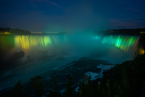 Canadian side view of Niagara Falls, American Falls, Horseshoe Falls, Niagara River, tourist atractions, casinos, fireworks and boat tours at sunset; Niagara Falls, Ontario, Canada