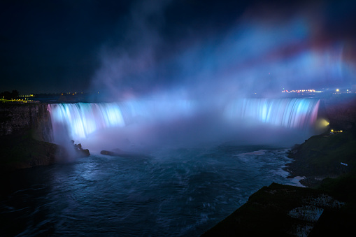 Canadian side view of Niagara Falls, American Falls, Horseshoe Falls, Niagara River, tourist atractions, casinos, fireworks and boat tours at sunset; Niagara Falls, Ontario, Canada