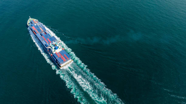 Stern of large cargo ship import export container box on the ocean sea on blue sky back ground concept transportation logistic and service to customer and supply change