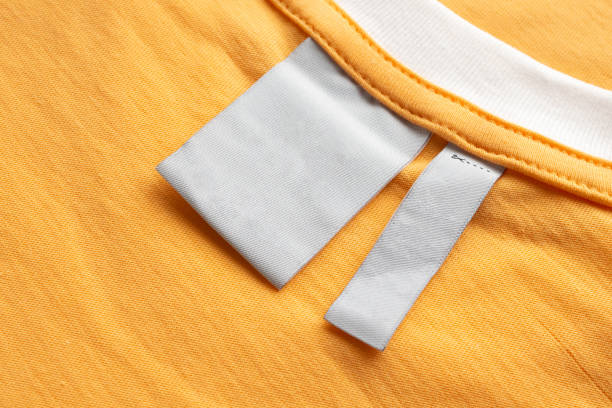 istock Blank white laundry care clothes label on yellow fabric texture background 1430510582