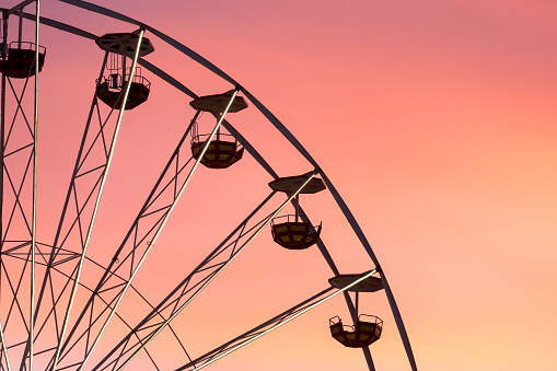 Ferris wheel at the picturesque pink colored sunset, closeup