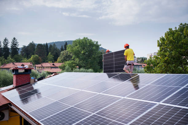 istock Team of workers carrying solar panels on rooftop. 1430510862