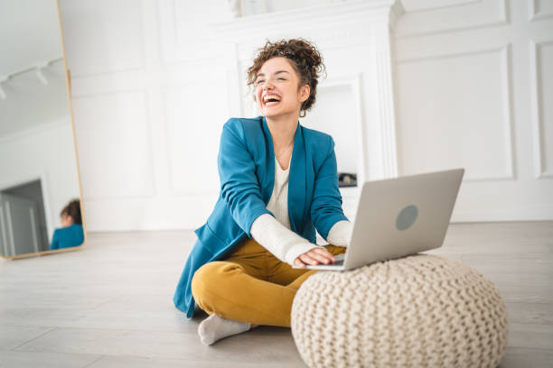 istock one woman young adult use computer while sitting on the floor at home 1430516363