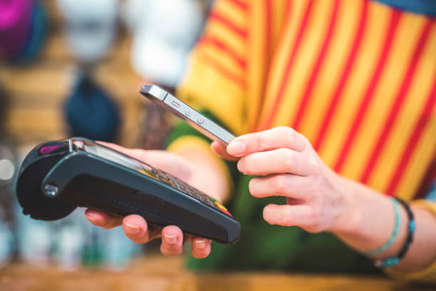 istock Hand of customer paying with contactless by mobile device. Payment with mobile. 1430520965
