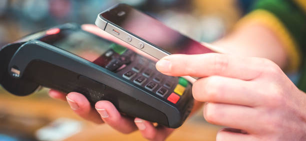 istock Hand of customer paying with contactless by mobile device. Payment with mobile. 1430520976