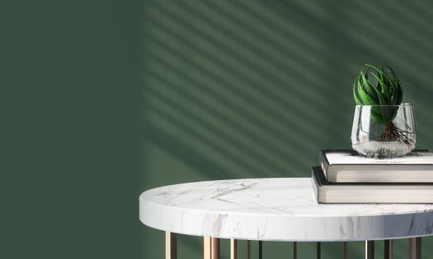 table d’appoint ronde moderne et luxueuse sur pied avec plateau en marbre blanc à la lumière du soleil des stores de fenêtre sur mur vert en arrière-plan - table basse photos et images de collection