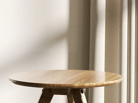 Clásica y lujosa mesa auxiliar redonda de pedestal de madera a la luz del sol desde la ventana con cortina beige y pared de fondo photo
