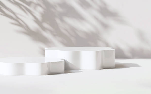 istock Elegant white glossy hexagon round pedestal podium with sunlight and leaf shadow on white wall 1430536188