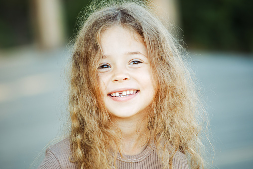 A beautiful little girl, eight years old, smiling at the camera.