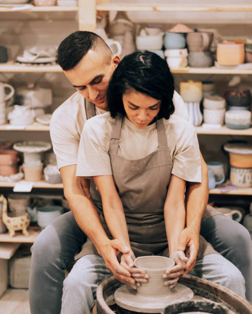 istock Couple in love working together on potter wheel in craft studio workshop. 1430542191