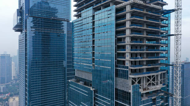 istock Two skyscrapers during construction. Skyscrapers under construction against the sky. Construction of glass skyscrapers. Facing of buildings with glass 1430544538