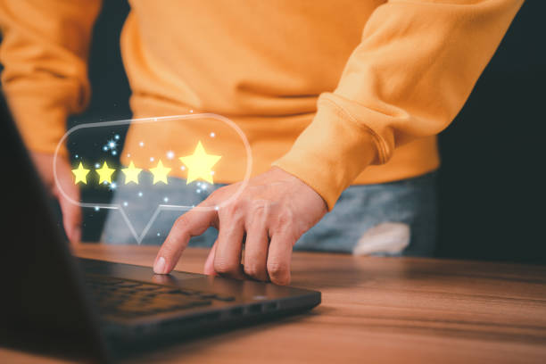 istock Man hand using computer laptop with popup five star icon for feedback review satisfaction service, testimonial. Customer service experience and business satisfaction survey. 1430544541