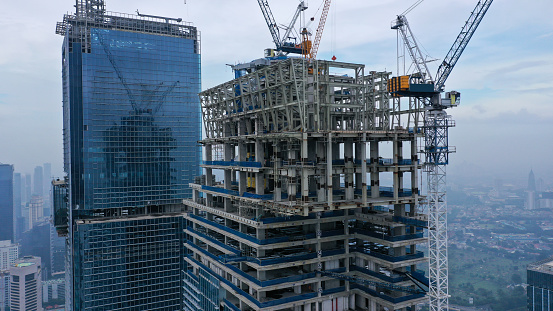 Skyscraper under construction, with crane on top, for urban and industrial themes.