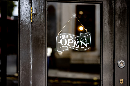 Close-up on a open sign hanging on the door of a restaurant - food and drink establishment concepts