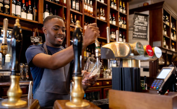 istock Happy barman serving some draught beer at the pub 1430548780