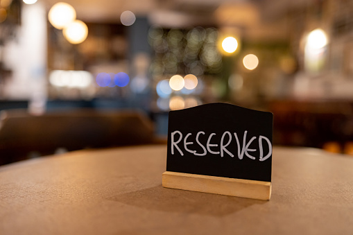 Close-up on a reserved sign on a table at a restaurant - food and drink establishment concepts