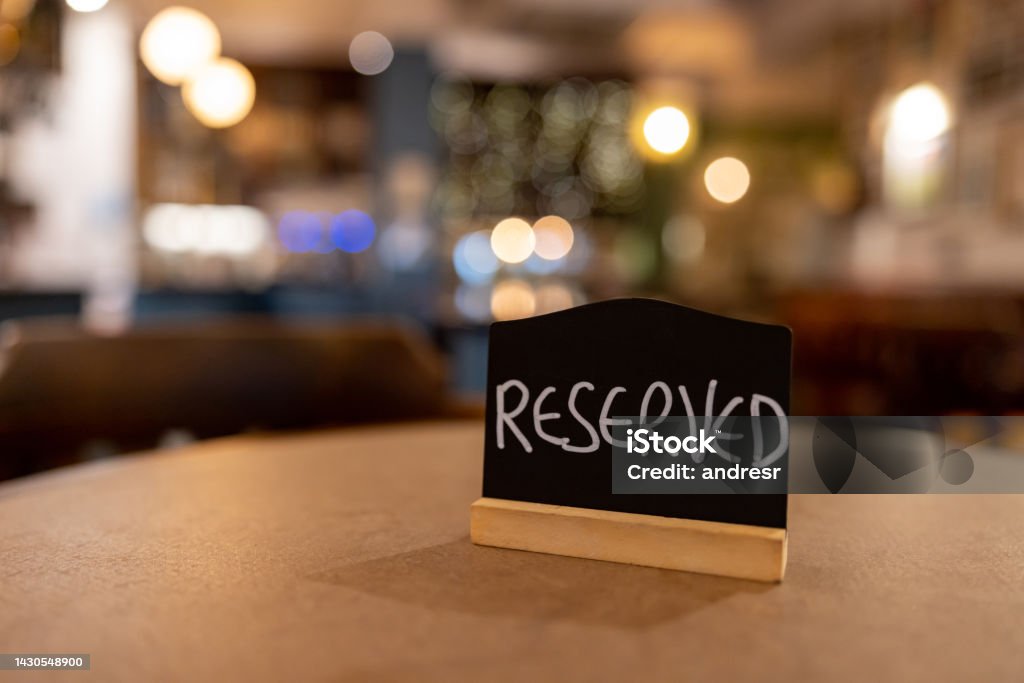 Close-up on a reserved sign on a table at a restaurant Close-up on a reserved sign on a table at a restaurant - food and drink establishment concepts Making a Reservation Stock Photo