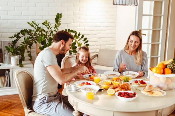 istock Happy young family having breakfast at home 1430553839