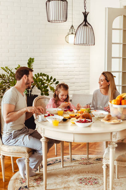 istock Happy young family having breakfast at home 1430553972