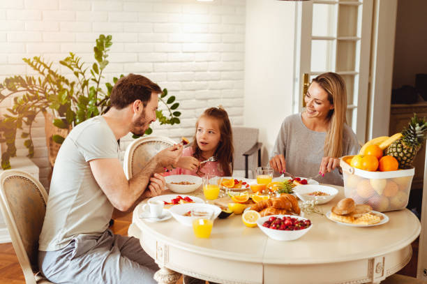 istock Happy young family having breakfast at home 1430553984