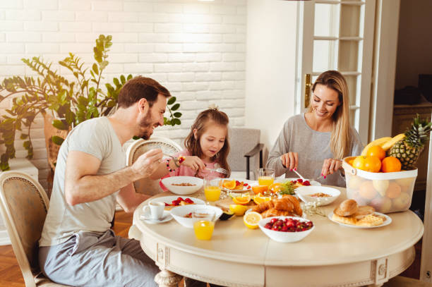 istock Happy young family having breakfast at home 1430553985